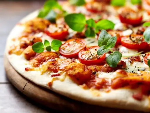 Pyszna pizza bez drożdży z pomidorkami koktajlowymi i świeżą bazylią, idealna na szybki obiad.