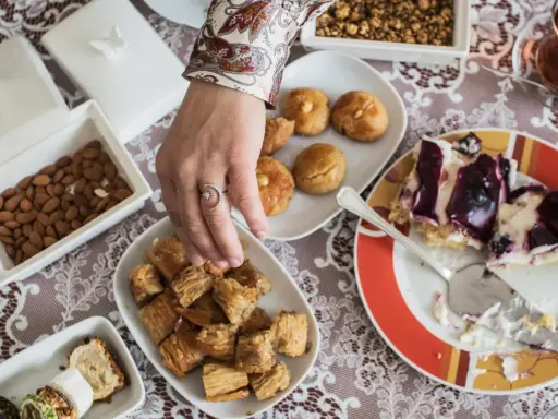 Ein Tisch voller Köstlichkeiten für das Ramadan Fest: Baklava, Kekse, Mandeln und ein Stück Kuchen.