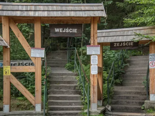 Kamienne schody prowadzą do wejścia na teren Szczelińca Wielkiego. Drewniane bramy z tablicami informacyjnymi zapraszają do zwiedzania.