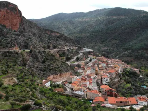 Pueblo encajado en un valle, con casas de tejados naranjas y una carretera serpenteante. Descubre qué ver en Ayna, un rincón pintoresco.
