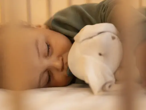 Dulce sueño de bebé de 6 meses, abrazando su peluche mientras duerme plácidamente en su cuna.