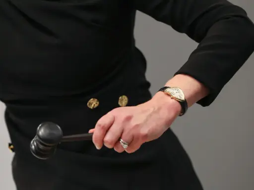 Auctioneer's hand with a gavel, ready to finalize an art loan.