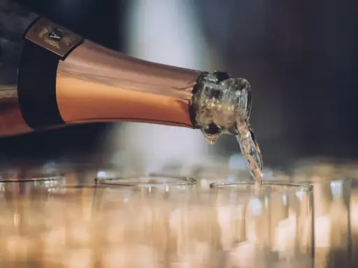 En flaska hälls upp i glas, det ser ut att bli gott bubbel.