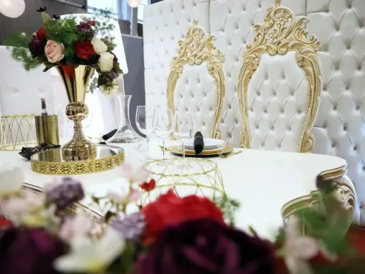 Elegancki stół z kwiatami i złotymi zdobieniami. Czy za ślub cywilny się płaci? Tutaj wszystko wygląda na luksusowe.