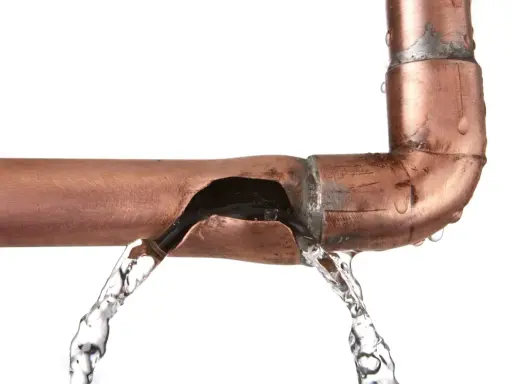 Fuite d'eau sur un tuyau en cuivre endommagé. Une solution pour réparer tuyau cuivre sans soudure est nécessaire.