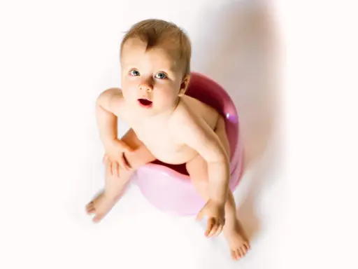 Bambino seduto sul vasino rosa, con espressione sorpresa. Attenzione alla cistite nei bambini.