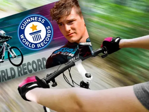 Kolarz w rękawiczkach ściga się na rowerze, celując w rekord prędkości na rowerze, z logo Guinness World Records.