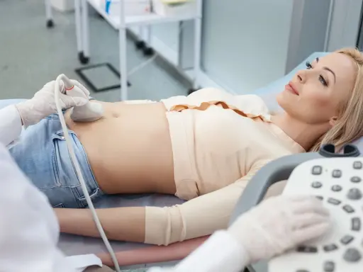 Kobieta leży na kozetce, a lekarz wykonuje jej cystografię mikcyjną, badając pęcherz moczowy.