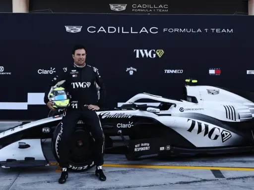 Checo Pérez posa junto a un coche de F1 de Cadillac.