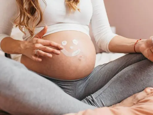 Ciężarna kobieta rysuje uśmiechniętą buźkę na brzuchu. Myśli o przyszłości, o zdrowiu dziecka i o tym, jak cenna jest krew pępowinowa.
