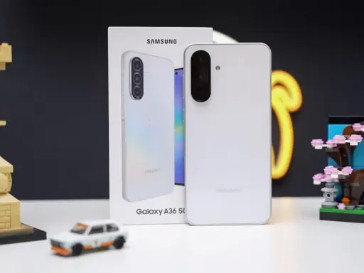 Biały Samsung Galaxy A36 5G, produkt największego producenta smartfonów, obok miniatury Japonii i modelu samochodu.