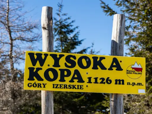 Żółta tablica informuje o szlaku na Wysoką Kopę (1126 m n.p.m.) w Górach Izerskich.