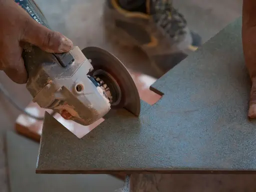 Mano sujetando una radial para cortar azulejos con precisión.