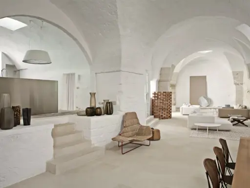 Interni moderni con volte a stella, arredi minimalisti e vasi decorativi.