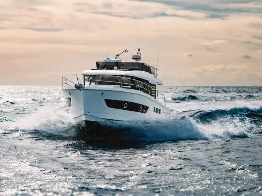 Un bateau blanc fend les vagues, le moteur de 20 cv propulsant l'embarcation à pleine vitesse.