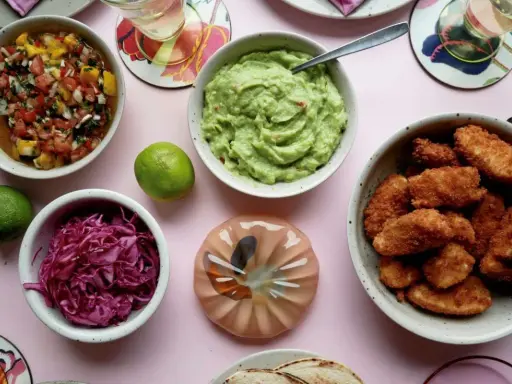 En skål med guacamole, salsa, rödkål och friterad kyckling – allt för ett lyxigt tacos recept.