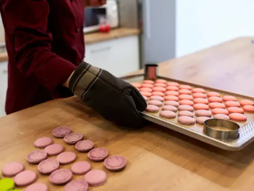 Préparation pour la cuisson macaron chaleur tournante : une plaque de macarons roses et roses est sortie du four.