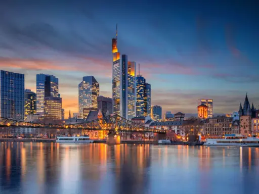 Frankfurter Skyline bei Sonnenuntergang mit Main und Brücke.