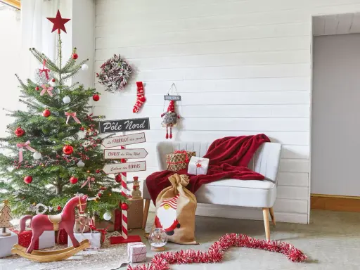 Un sapin décoré, des cadeaux et un fauteuil rouge invitent à faire des décorations de Noël. Un panneau "Pôle Nord" indique la direction.