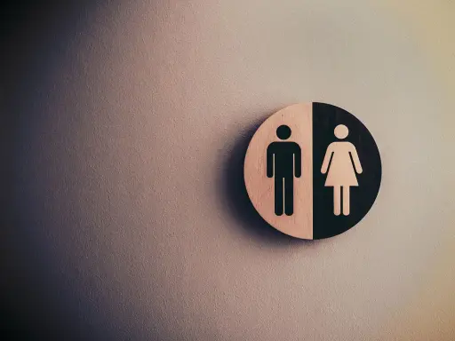 Symbol płci na tle ściany. Fizjoterapia uroginekologiczna dla każdego.