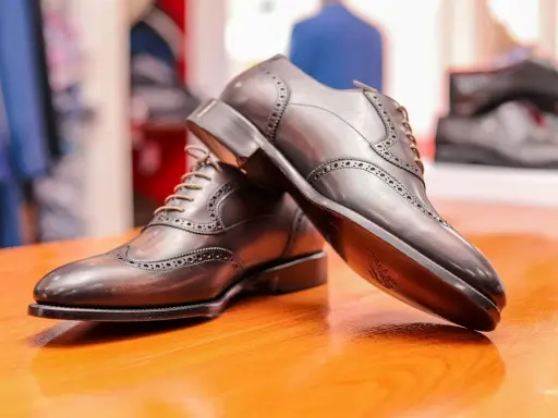 Eleganckie, brązowe półbuty męskie z ażurowymi zdobieniami. Zastanawiasz się, co to zelówka? To podeszwa buta, która zapewnia komfort i przyczepność.