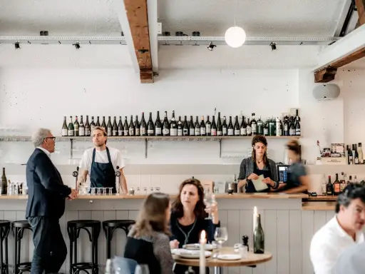 Un bar de restaurant moderne avec des employés derrière le comptoir, respectant les normes d'hygiène et de service.