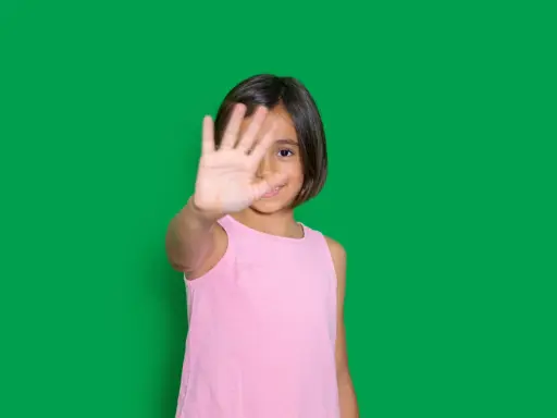 Niña de 4-5 años muestra timidez en niños, cubriendo su rostro con la mano.