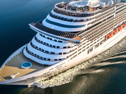 La MSC Preziosa solca il mare blu. L'equipaggio nave da crociera si prepara per un nuovo viaggio, con le scialuppe di salvataggio pronte.