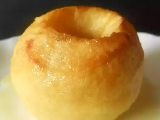 Une pomme au four dorée, creusée et prête à être garnie. Un délice simple et réconfortant.