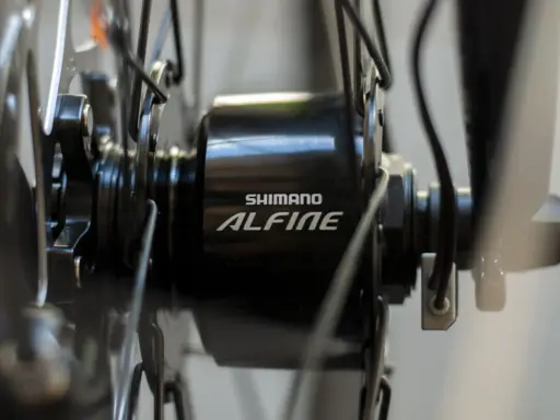 Szczegół piasty rowerowej Shimano Alfine z widocznym kablem, który jest kluczowy, by dowiedzieć się jak włączyć dynamo w rowerze.