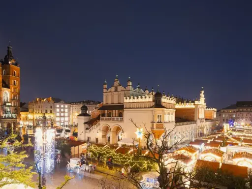 Kraków atrakcje zimą: Rynek Główny nocą, iluminacje świąteczne, Sukiennice, Kościół Mariacki i wieża ratuszowa.