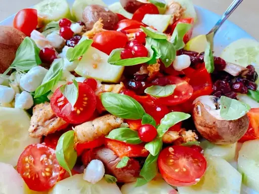 Salade colorée avec poulet, tomates, concombre, mozzarella et fruits rouges. Une excellente idée repas froid midi, fraîche et savoureuse.