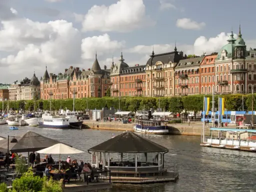 En dag i Stockholm vid vattnet med vackra byggnader, båtar och uteserveringar.