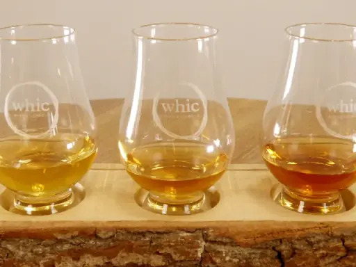 Fünf Gläser mit unterschiedlichen Farben von **whiskey ohne farbstoff** stehen auf einem Holzbrett.