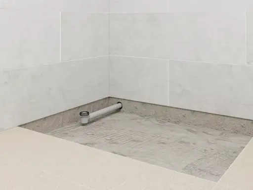 Installation d'un receveur de douche : un siphon est posé sur une chape avant le carrelage.