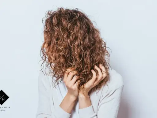 Frauen mit einer voluminösen Dauerwelle, die ihre Hände durch die Locken gleiten lassen.