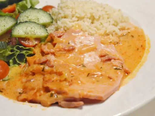 Kassler i ugn med krämig sås, serverad med couscous och en fräsch sallad med tomat och gurka. En härlig middag!