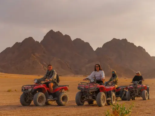 Un gruppo di persone si diverte in quad nel deserto egiziano, un'avventura indimenticabile a Sharm el Sheikh con bambini.
