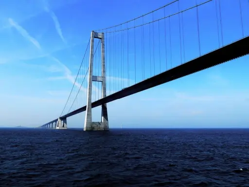 El puente del Gran Belt se extiende majestuosamente sobre el mar azul bajo un cielo despejado.