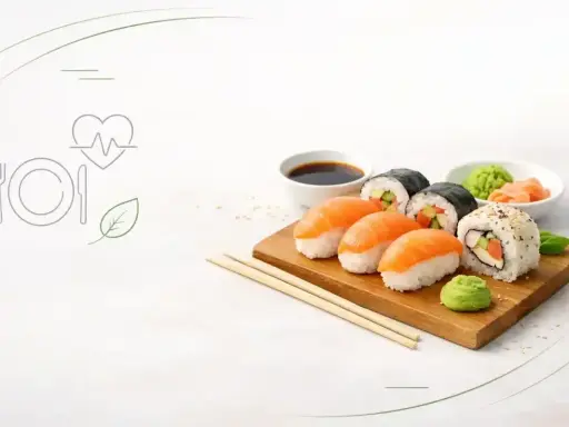 Czy sushi jest zdrowe? Na talerzu nigiri z łososiem, rolki maki z ogórkiem i awokado, sos sojowy, wasabi i imbir. Obok ikony serca z pulsem i liścia.