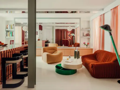 Un soggiorno con mobili colorati e un bancone da bar a righe. Stanza particolari in una casa che invita al relax e alla convivialità.