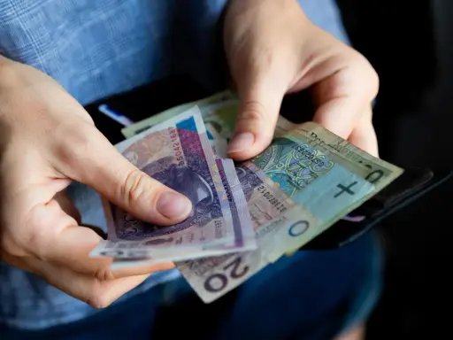 Ręce liczą banknoty, zastanawiając się, ile lat pracy do emerytury.