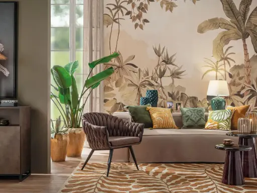 Un salotto con un murale botanico, mobili eleganti e raffinate decorazioni. Un divano beige, una poltrona marrone e un tappeto animalier creano un'atmosfera accogliente.