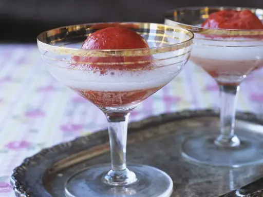 Zwei Gläser Champagner mit Erdbeeren, die auf einem Silbertablett stehen. Ein erfrischender Genuss.