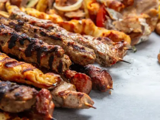 Grillowane szaszłyki z mięsem i warzywami, pyszna turecka potrawa, podane z chlebkiem pita i frytkami.