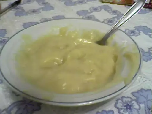 Un tazón blanco con un suave y cremoso puré de pescado, listo para ser disfrutado. Una cuchara plateada descansa en el tazón.