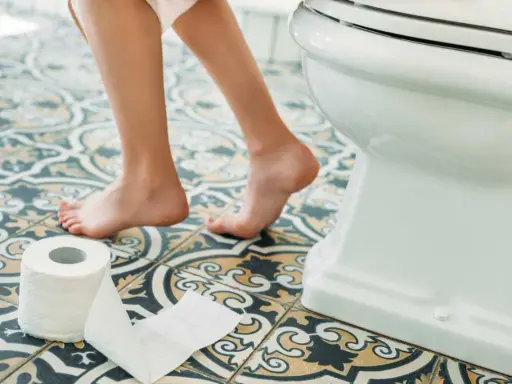Nagość stóp na wzorzystej podłodze, obok toalety i rolki papieru. Po intymnych chwilach, jak sikanie po seksie, toaleta jest naturalnym miejscem.