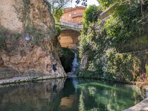 Un hombre posa junto a una cascada en un estanque natural en Ferez, Albacete.