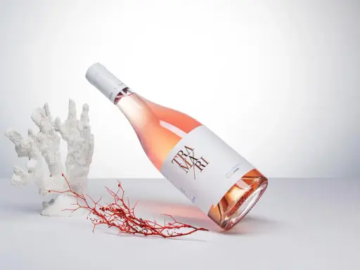 Flasche Roséwein von Cantine San Marzano, umgeben von Korallen und Seetang, auf hellem Hintergrund.