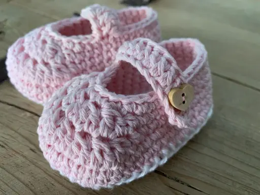 Patucos de ganchillo de 0 a 3 meses, con un patrón delicado y un botón de corazón. Perfectos para un bebé.
